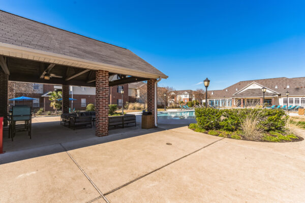 Covered outdoor lounge and grilling area beside pool at The Overlook student apartments near SFA
