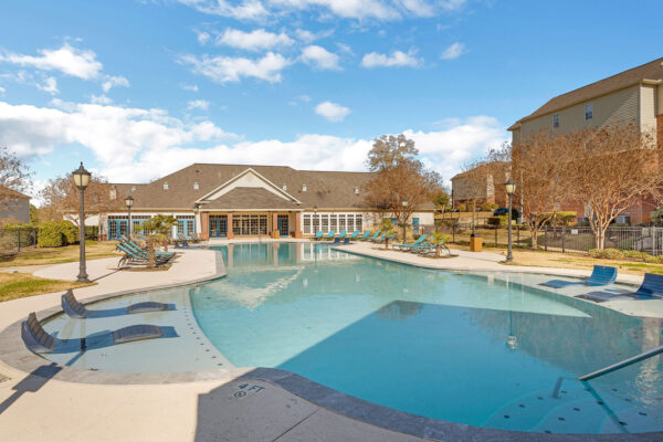 Resort-style pool with lounge chairs and clubhouse exterior at The Overlook student apartments near SFA