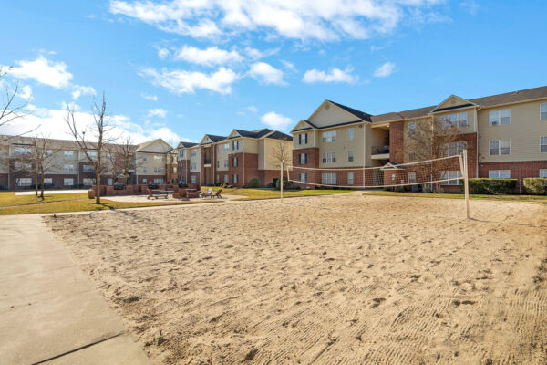 Sand volleyball court with fire pit area at The Overlook student apartments near SFA Nacogdoches