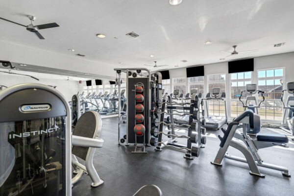 24-hour fitness center with weight machines and cardio equipment at The Overlook student apartments near SFA